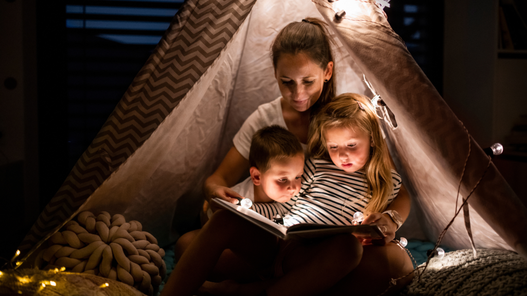 Family reading together inside a blanket fort during story time.
