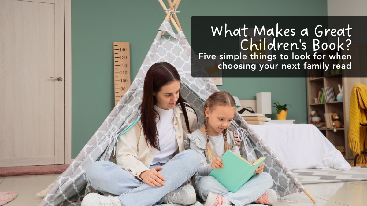 Mother and daughter reading a picture book together inside a cozy teepee reading nook at home.
